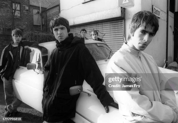 Group portrait of British rock band Oasis leaning against a Jaguar XJ6 car in Withington, Manchester, United Kingdom, 30th November 1993. L-R Paul...