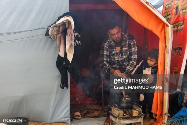 Displaced Palestinian man, who fled the northern Gaza Strip due to Israeli bombardment, sits in a makeshift shelter on the grounds of the Nasser...