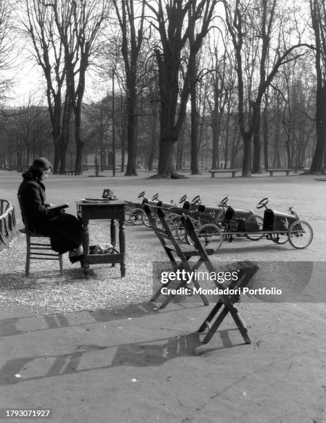 Woman waits for customers at the pedal car rental at Giardini Pubblici, now Giardini Montanelli. Milan , 1950 SPECIAL FEE - CONTACT US FOR EVERY USAGE