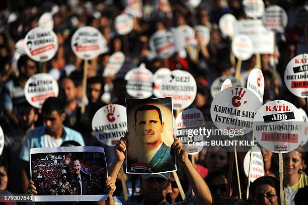 Protester holds a portrait of Syrian President Bashar al-Assad during a rally on September 1 in Hatay against a possible attack on Syria in response...