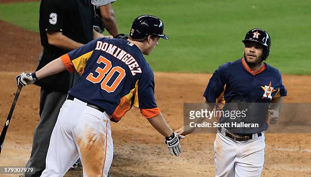 Matt Dominguez and Jose Altuve of the Houston Astros celebrate at home plate after Altuve scored a run in the eighth inning against the Seattle...