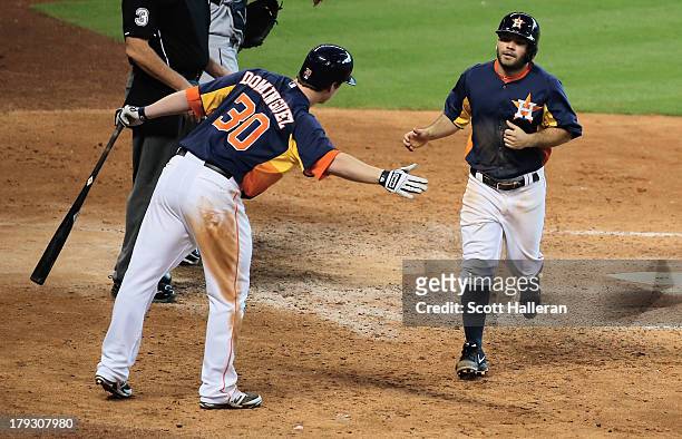 Matt Dominguez and Jose Altuve of the Houston Astros celebrate at home plate after Altuve scored a run in the eighth inning against the Seattle...