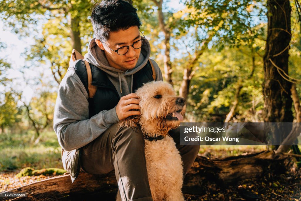Young Asian man exploring nature with his dog