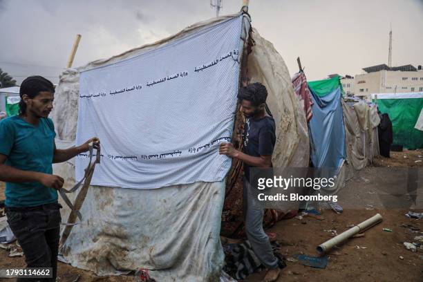 Men build temporary shelters in a camp for displaced Palestinians near the Shuhada Al-Aqsa hospital in Deir al-Balah, Gaza, on Monday, Nov. 13, 2023....