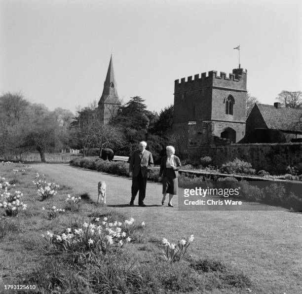 Ivo Murray Twisleton-Wykeham-Fiennes, 20th Baron Saye and Sele , and his wife Hersey walking in the grounds of Broughton Castle with their greyhound,...