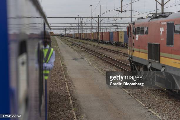 Transnet freight trains pass shipping containers at the Transnet SOC Ltd. Sentrarand depot, in the Benoni district of Gauteng, South Africa, on...
