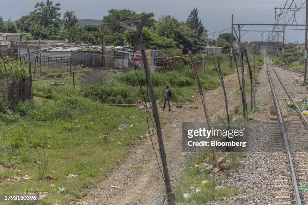 Wiring for an illegal electrical supply, connected to power lines on the central corridor rail freight line, runs towards an illegal housing...