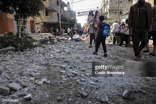 Palestinians walk over blast rubble following an Israeli military strike on a market in Deir al-Balah, Gaza, on Monday, Nov. 13, 2023. While Israel...