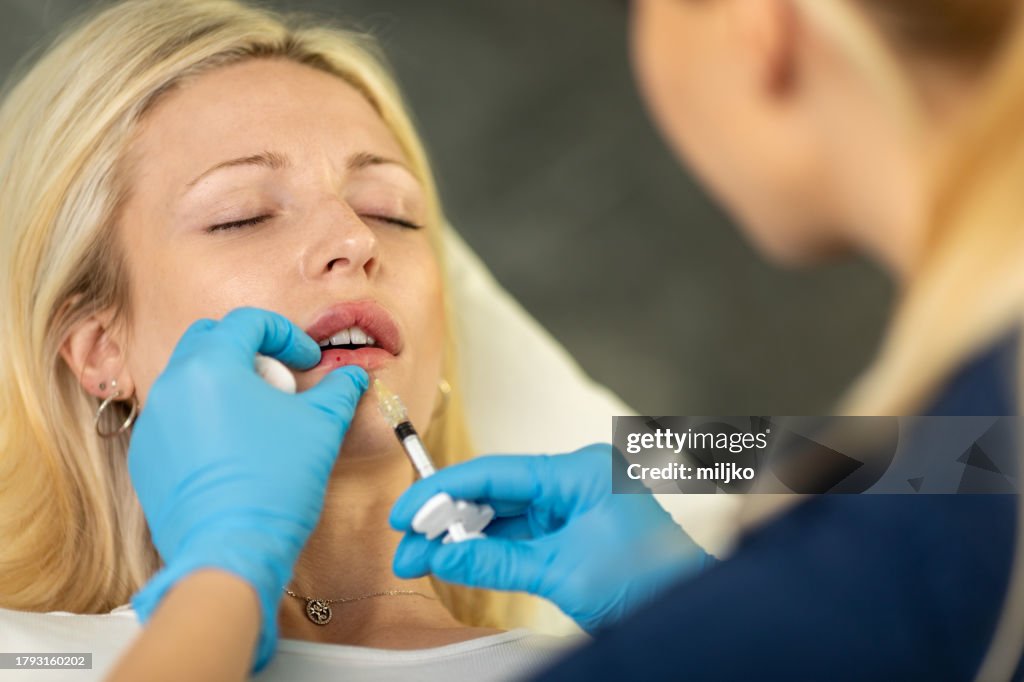 Young woman having hyaluronic lip treatment