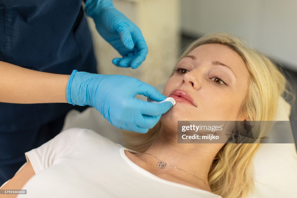 Young woman having hyaluronic lip treatment