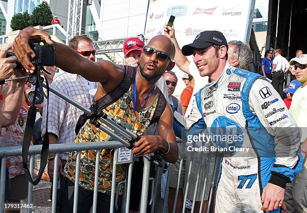 Simon Pagenaud, of France, driver of the Schmidt Hamilton Motorsports Honda Dallara poses for a photo with a fan in victory lane after winning the...