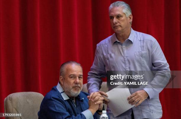 Cuban President Miguel Díaz Canel walks to deliver a speech as Prime Minister Manuel Marrero looks on during the closing of the IV Conference "Nation...