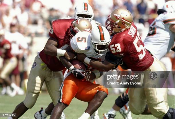 Running back Edgerrin James of the Miami Hurricanes gets tackled during a game against the Florida State Seminoles at Doak S. Campbell Stadium in...