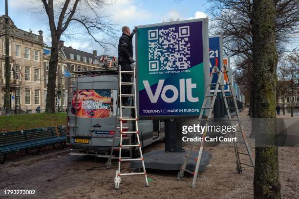 Worker repairs a damaged poster for the Volt Netherlands party ahead of Wednesday's general election, on November 20, 2023 in The Hague, Netherlands....