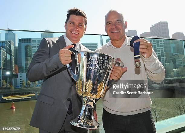 Former AFL players Shane Crawford and Greg Williams hold the 2013 AFL Premiership Cup and the Norm Smith Medal during the 2013 AFL Finals Series...