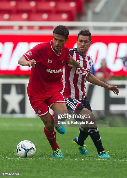 Patricio Araujo of Chivas competes for the ball with Francisco Gamboa of Toluca during a game between Chivas and Toluca as part of the Torneo...