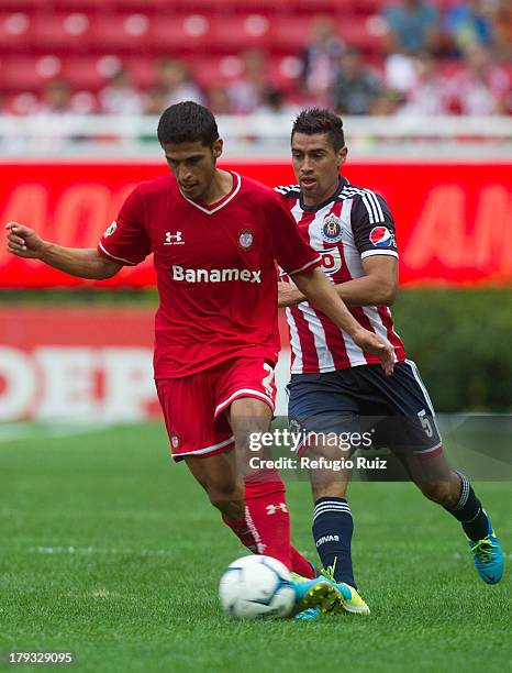 Patricio Araujo of Chivas competes for the ball with Francisco Gamboa of Toluca during a game between Chivas and Toluca as part of the Torneo...