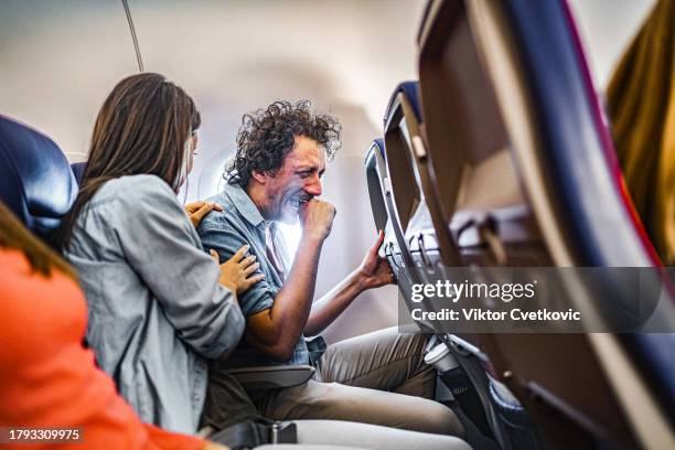 male passenger having a panic attack on airplane flight - pressure airplane stock pictures, royalty-free photos & images