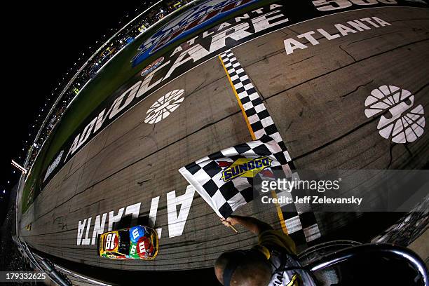 Kyle Busch, driver of the M&M's Toyota, crosses the finish line to win the NASCAR Sprint Cup Series AdvoCare 500 at Atlanta Motor Speedway on...