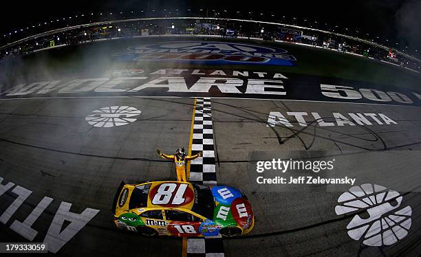 Kyle Busch, driver of the M&M's Toyota, celebrates after winning the NASCAR Sprint Cup Series AdvoCare 500 at Atlanta Motor Speedway on September 1,...