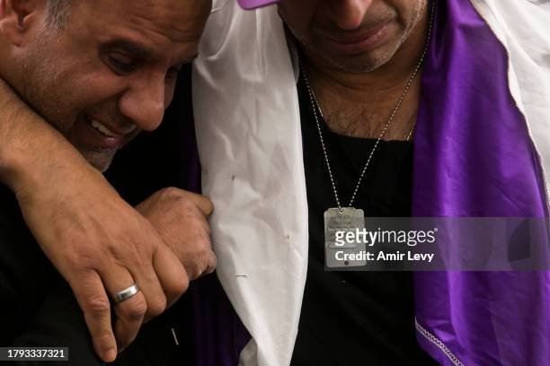 Man wears a dog tag saying "Bring them home" as he is mourning during a funeral for Lt. Adir Portugal on November 20, 2023 in Mazkeret Batya, Israel....