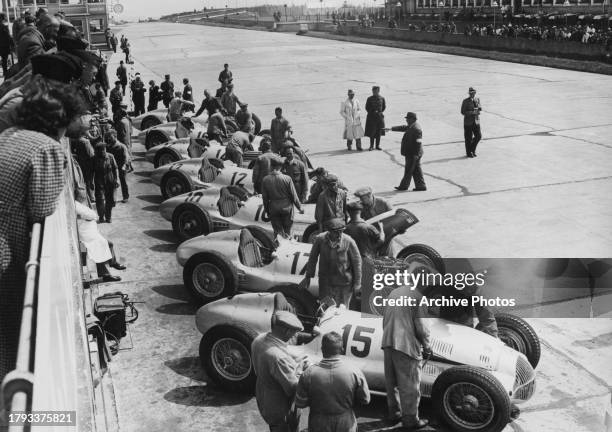 Mechanics and engineers from the Mercedes-Benz racing team prepare the seven Daimler-Benz AG Mercedes-Benz W154 racing cars for their drivers Rudolf...