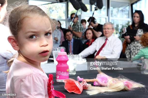 Australian Prime Minister, Kevin Rudd looks on as a young girl appears disinterested at Bramble Bay Bowls Club on September 2, 2013 in Woody Point,...