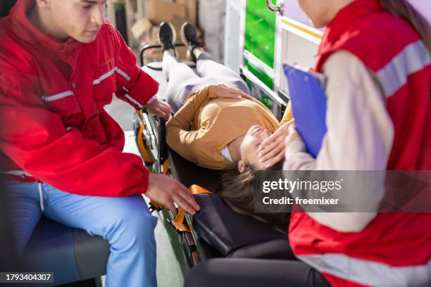 medical emergency team helping injured young woman - injured nurse stock pictures, royalty-free photos & images