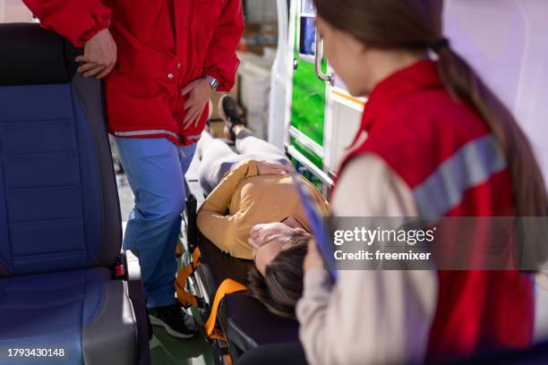 medical emergency team helping injured young woman - injured nurse stock pictures, royalty-free photos & images