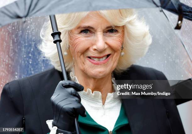 Queen Camilla shelters under an umbrella as she, to mark The King's 75th birthday today, officially launches The Coronation Food Project at the South...