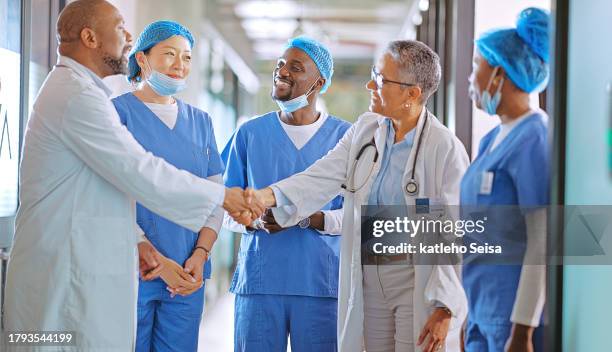 healthcare, teamwork and doctors shaking hands in a hospital for thank you, achievement or congratulations. handshake, welcome or support with a professional man and woman medicine group in a clinic - success stock pictures, royalty-free photos & images