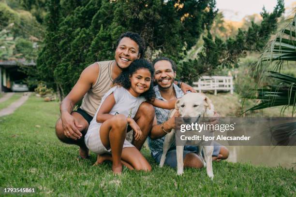 retrato de pareja gay con hija y perro en el patio trasero - música latinoamericana fotografías e imágenes de stock