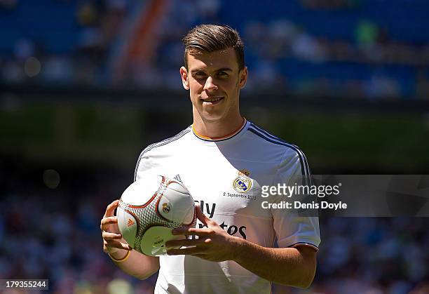 Gareth Bale poses for photographs in his new Real Madrid shirt during his official unveiling at estadio Santiago Bernabeu on September 2, 2013 in...