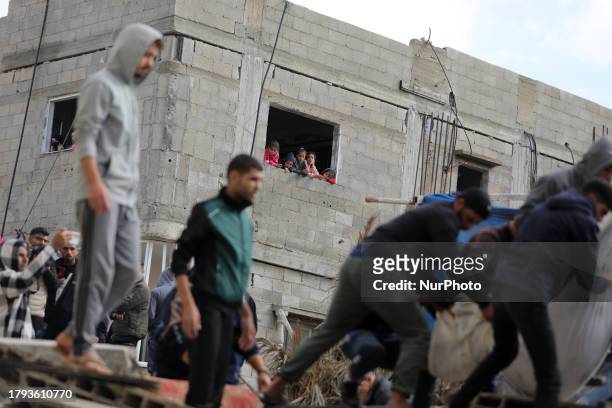 Palestinians carry a person injured in an Israeli strike in Deir el-Balah, in the central Gaza Strip, on November 20 amid continuing battles between...