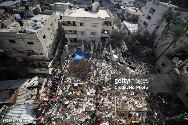 Palestinians search through the rubble of a collapsed building searching for survivors and victims following the Israeli bombardment of Deir...