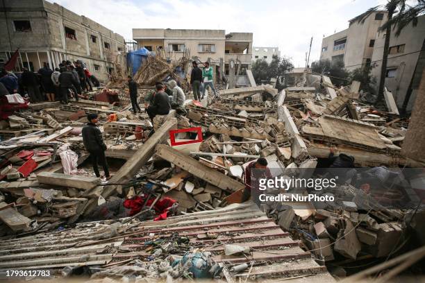 Palestinians search through the rubble of a collapsed building searching for survivors and victims following the Israeli bombardment of Deir...