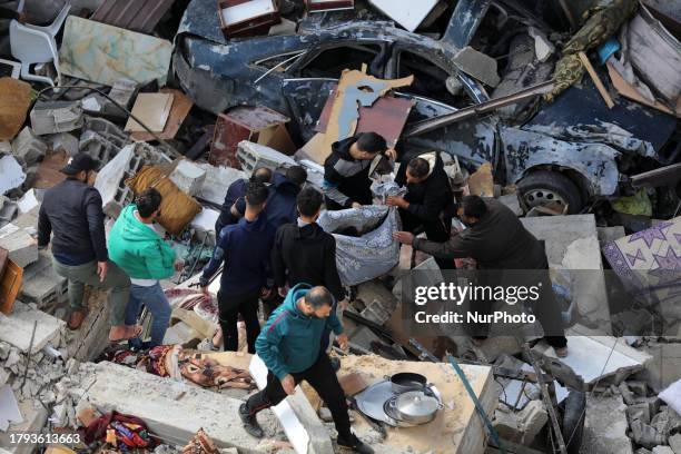 Palestinians carry a person injured in an Israeli strike in Deir el-Balah, in the central Gaza Strip, on November 20 amid continuing battles between...