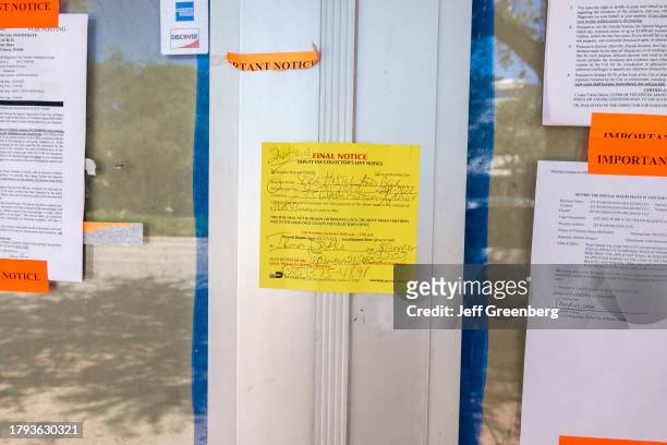 Miami Beach, Florida, empty deputy tax collector's levy notice for code violations on business door.