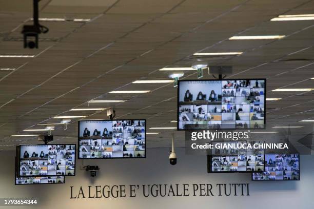 Courtroom monitors display the defendants listening to the verdict at the maxi mafia-trial in Lamezia Terme on November 20, 2023 where some 200...