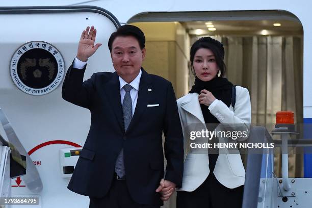 South Korea's President Yoon Suk Yeol and his wife Kim Keon Hee disembark from an aircraft after landing at London Stansted Airport on November 20...