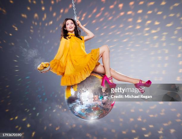 In this image released on November 21 Sophie Ellis-Bextor swings on a giant glitterball starring in a new campaign to launch McCain Baby Hasselbacks...