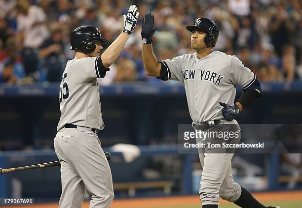 Alex Rodriguez of the New York Yankees is congratulated by Lyle Overbay after hitting a solo home run in the fifth inning during MLB game action...