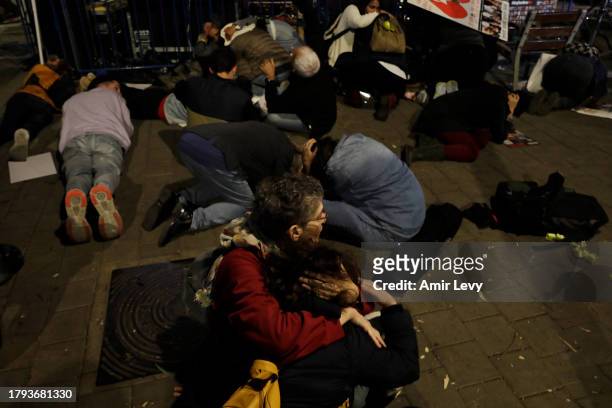 Protesters brace themselves on the ground, seeking cover as a red alert siren goes off as a rocket is fired from Gaza on November 20, 2023 in Tel...