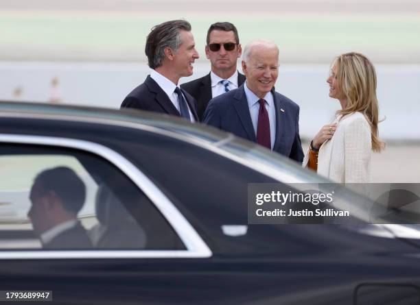 President Joe Biden talks with California Governor Gavin Newson and his wife Jennifer Siebel Newsom after arriving at San Francisco International...