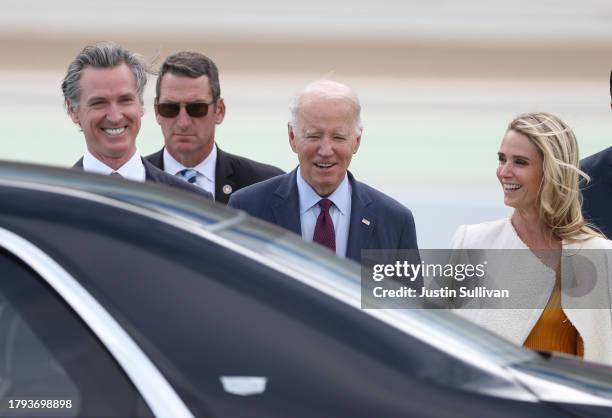 President Joe Biden talks with California Governor Gavin Newso and his wife Jennifer Siebel Newsom after arriving at San Francisco International...