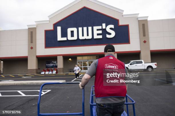 Worker moves empty carts outside a Lowe's store in Albany, New York, US, on Tuesday, Nov. 14, 2023. Lowe's Cos. Is expected to release earnings...