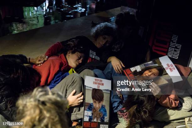 People take cover as siren for falling rockets is heard during a rally on November 20, 2023 in Tel Aviv, Israel. Families of hostages and their...