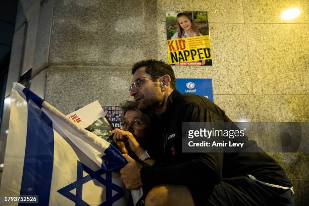 People take cover as siren for falling rockets heard during a rally on November 20, 2023 in Tel Aviv, Israel. Families of hostages and their...