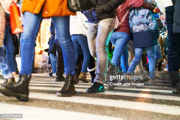 legs of people walking on the street wearing pants at a crosswalk at night, side view - busy sidewalk stock pictures, royalty-free photos & images