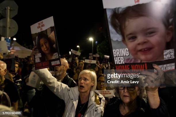People hold signs with photos of children, who are held hostage in Gaza Strip, during a rally on Novenmber 20, 2023 in Tel Aviv, Israel. Families of...